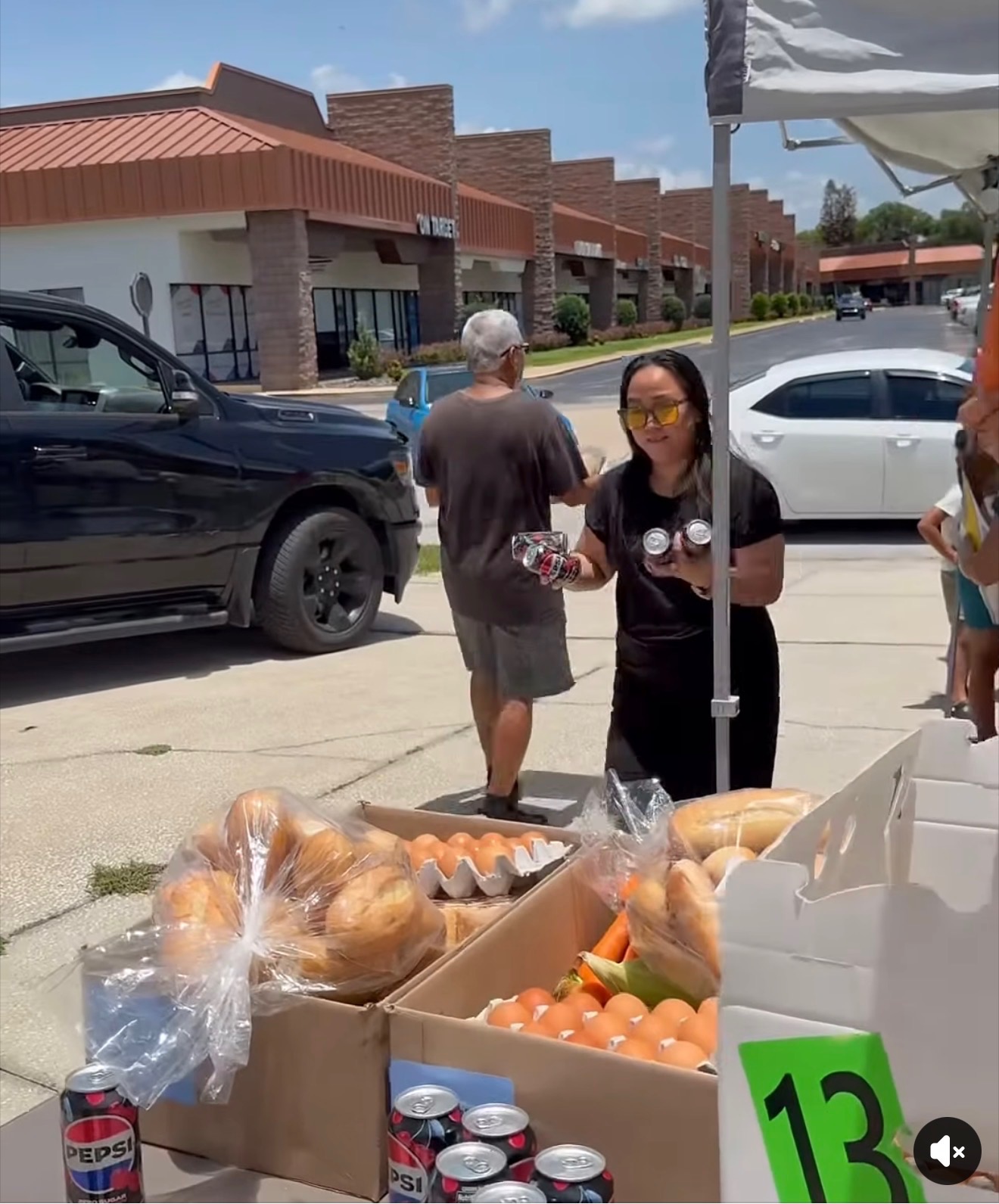 A smiling vendor at a roadside stand with drinks, eggs and produce
