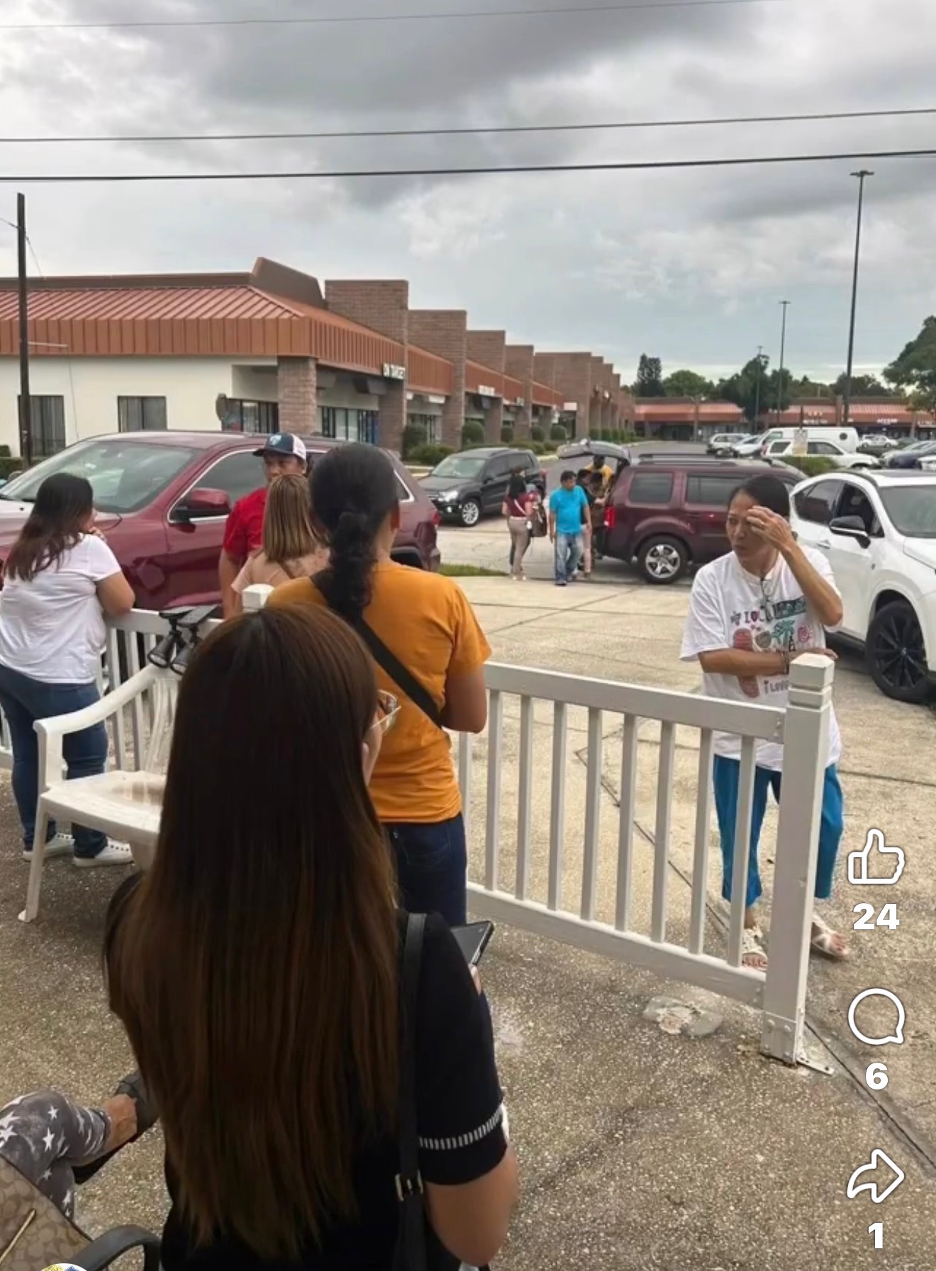 A group of neighbors gathered outside near a fence on a distribution day